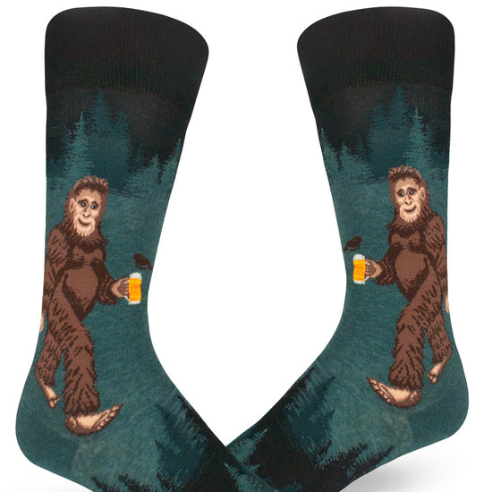 Men's crew socks in dark teal with a Sasquatch holding a beer in a forest.