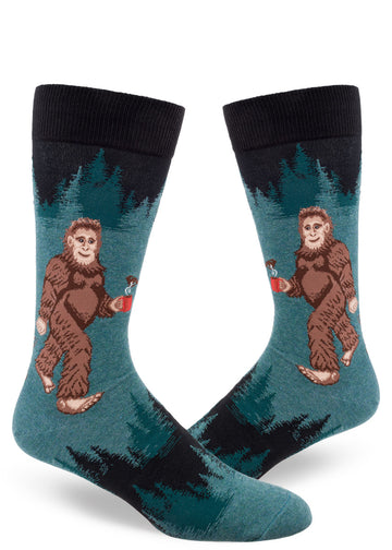 Dark teal men's crew socks with Sasquatch holding a mug of coffee with forest tree pattern above and below.
