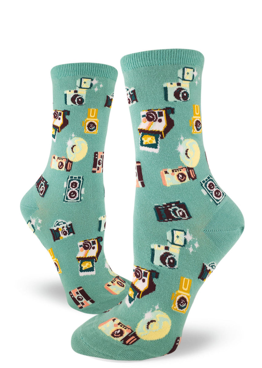 Light teal crew socks for women with allover repeating pattern of vintage cameras.