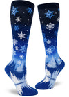 Blue knee-high socks with an allover pattern of falling snowflakes above a scene of a peaceful forest and lake in nighttime.