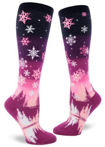 Pink gradient knee socks with pink and white snowflakes above falling on trees below.