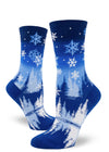 Blue and white crew socks for women with  snowflakes falling over a pond surrounded by snowy trees on a winter night.