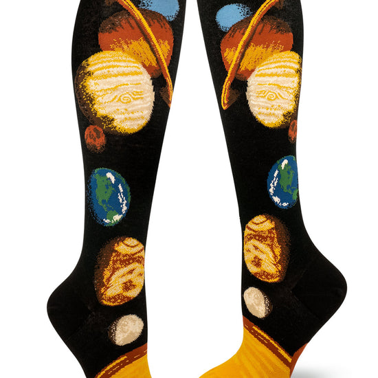 Black background knee socks with a colorful solar system design that includes all the planets aligned leading upward from the sun at the base.