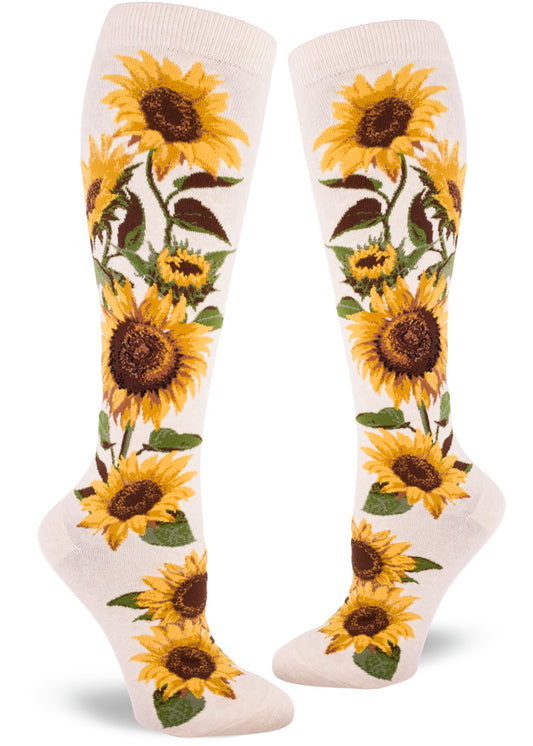 Cream colored knee-high socks featuring bold realistic sunflowers with yellow petals and brown centers and green foliage.