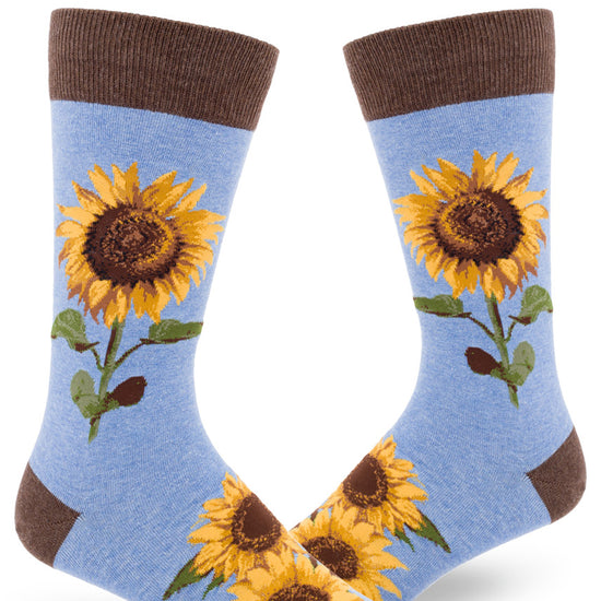 Men's sunflower crew socks in light blue with brown cuff featuring large yellow flowers with brown centers and green leaves.