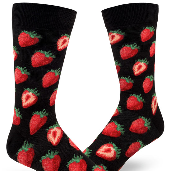 Black background crew socks for men with repeating allover pattern of red strawberries both whole and cut in half.