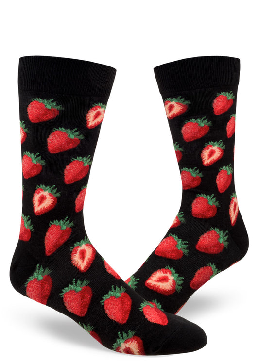 Black background crew socks for men with repeating allover pattern of red strawberries both whole and cut in half.