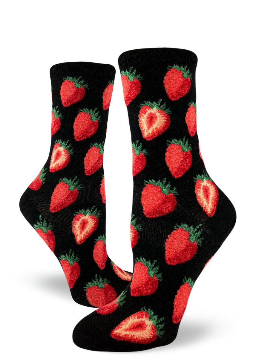 Women's black crew socks with repeating allover pattern of red strawberries whole and cut in half.