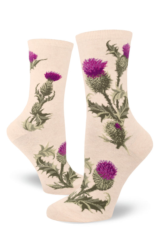 Cream-colored crew socks for women with thistle flower pattern featuring purple blossoms and prickly green buds, leaves and stems.