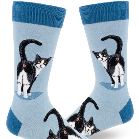 Light blue men's novelty crew socks with black and white tuxedo cats showing their butts with their tails raised and faces turned backward.