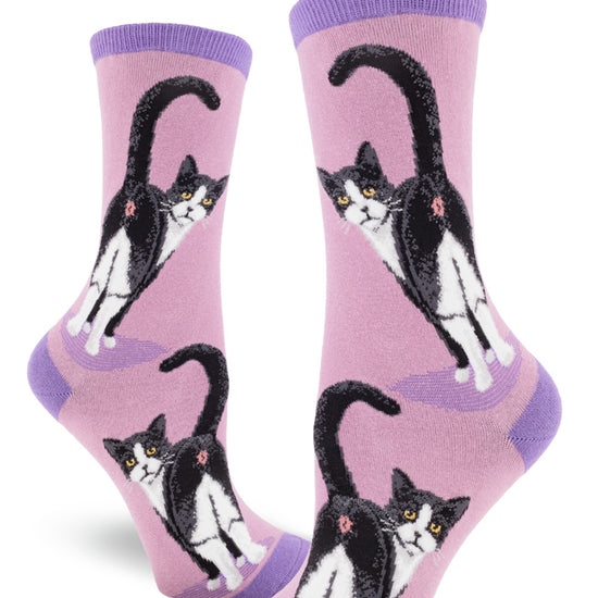 Purple crew socks for women featuring a black and white cat with yellow eyes showing its rear end, with its tail raised.