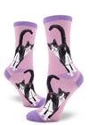 Purple crew socks for women featuring a black and white cat with yellow eyes showing its rear end, with its tail raised.