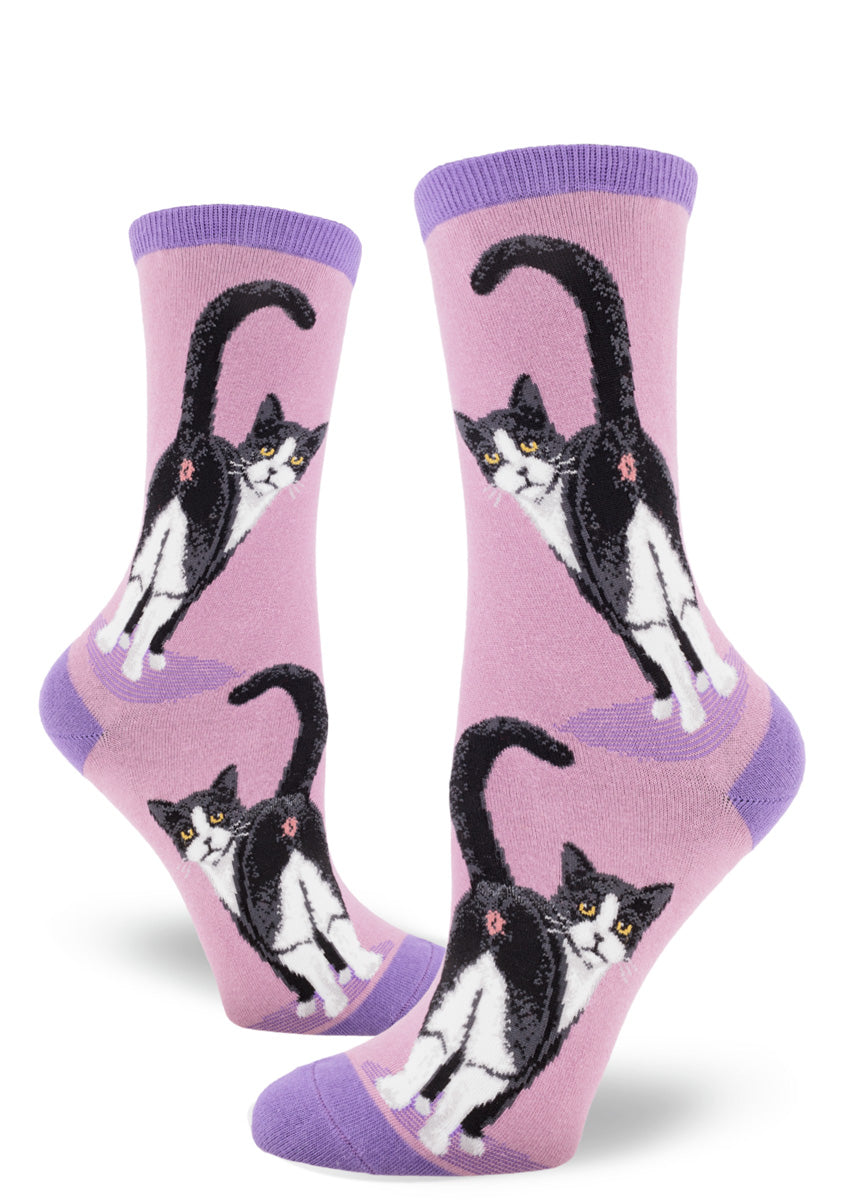 Purple crew socks for women featuring a black and white cat with yellow eyes showing its rear end, with its tail raised.