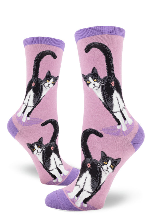 Purple crew socks for women featuring a black and white cat with yellow eyes showing its rear end, with its tail raised.