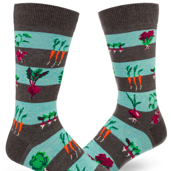 Blue and gray-brown striped men's crew socks with vegetables growing in dirt including carrots, beets, onions and more
