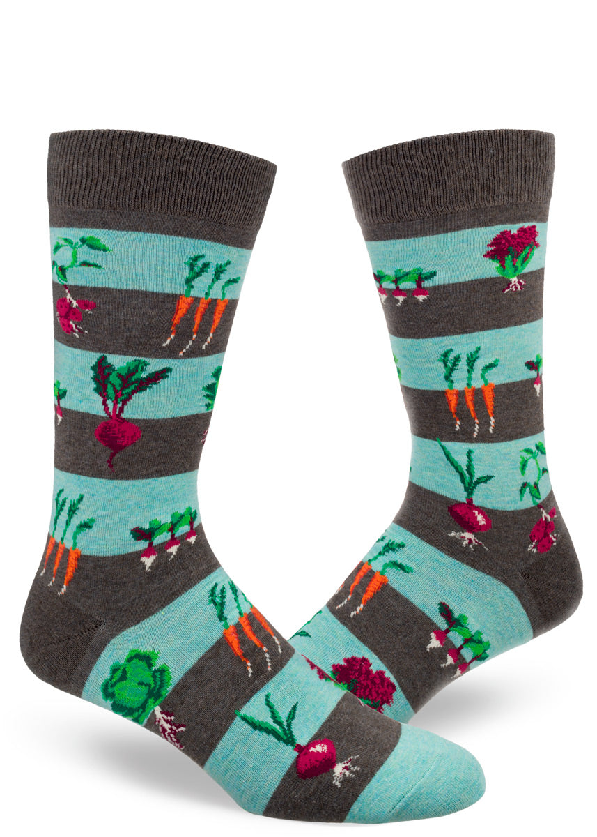 Blue and gray-brown striped men's crew socks with vegetables growing in dirt including carrots, beets, onions and more