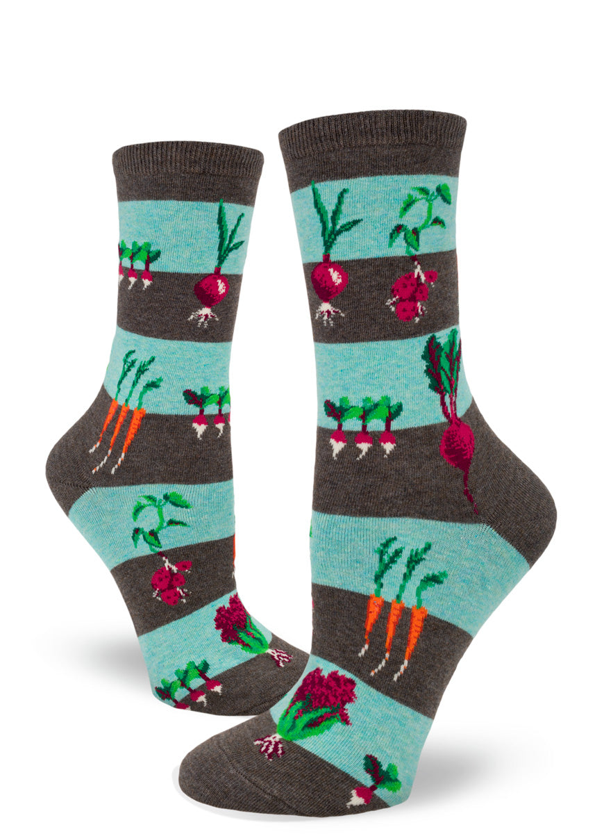 Striped crew socks for women in light blue and brown with a pattern of garden vegetables growing in the earth including carrots, beets, onions and more.