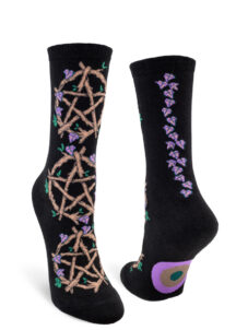 Women's crew socks with a black background featuring a pattern of pentacles made from twigs with purple vines and green leaves interspersed, plus a purple vine up the backseam.